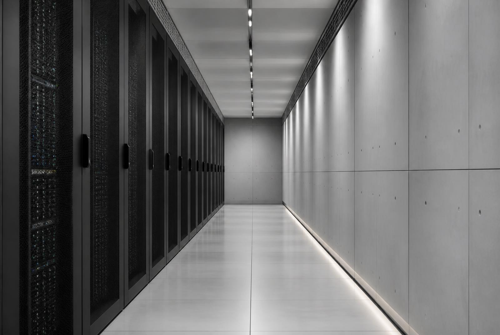 Minimal grey corridor of server racks inside a modern data centre